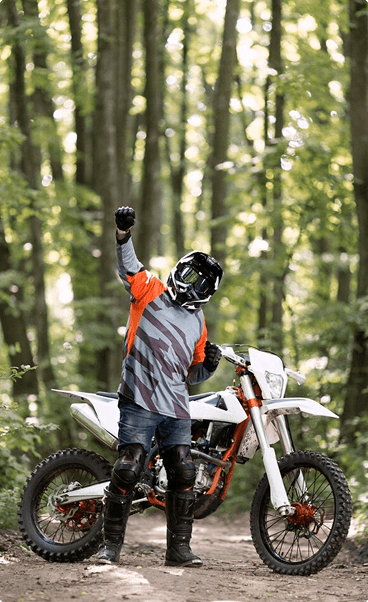 Motorcross rider celebrating in forest